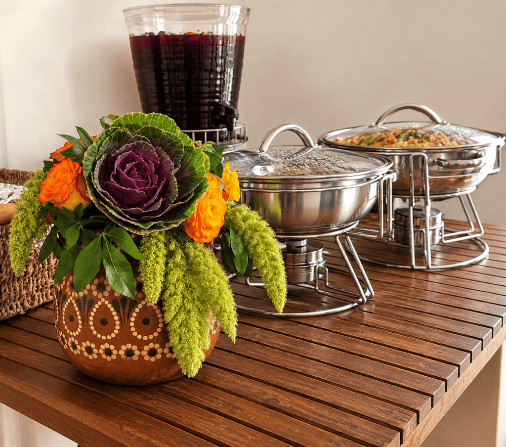 Mesa de taquiza en casa con chafers, agua de jamaica y centro de mesa en olla de barro